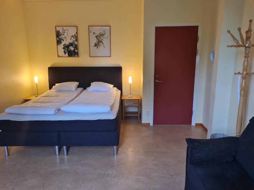 ビルヘルミーナにあるDalasjö vandrarhemのベッドルーム1室(ベッド2台、赤いドア付)