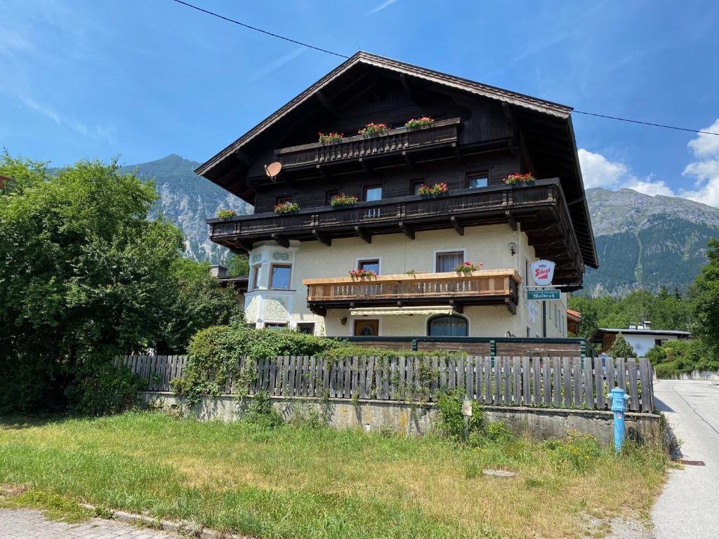 une maison avec un balcon et une clôture dans l'établissement Waldruh, à Wiesing