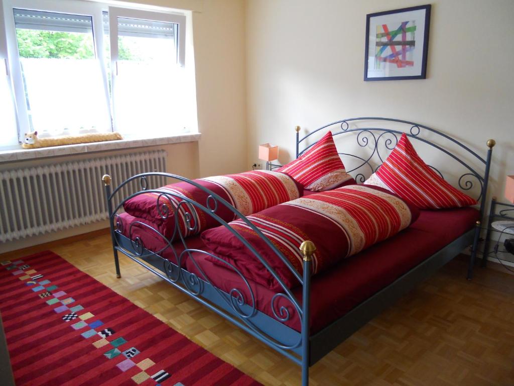 a bed with red pillows on it in a room at Haus Gisela in Endingen