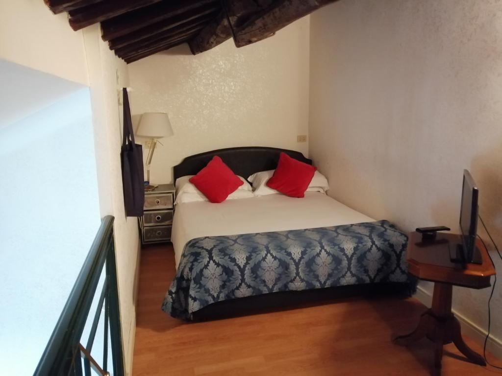 um quarto com uma cama com almofadas vermelhas em Residenza Monti em Roma