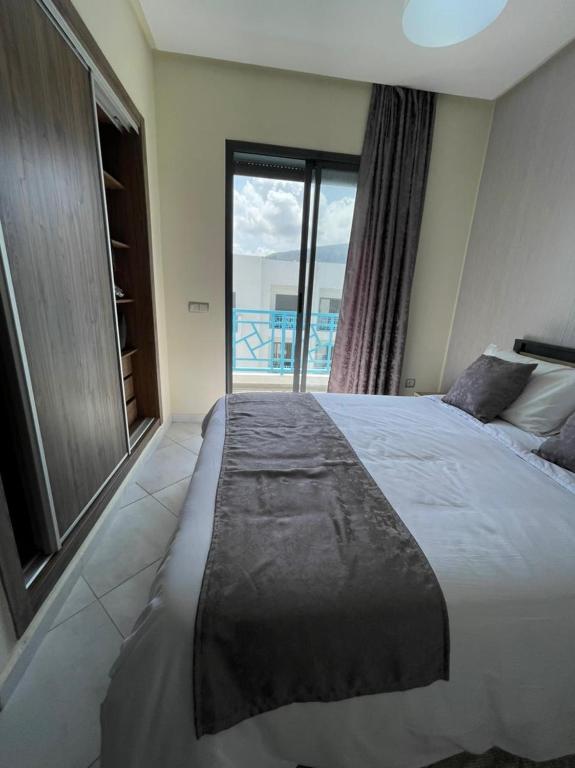 a bedroom with a large bed with a large window at APPART SMIR PARK in Tétouan