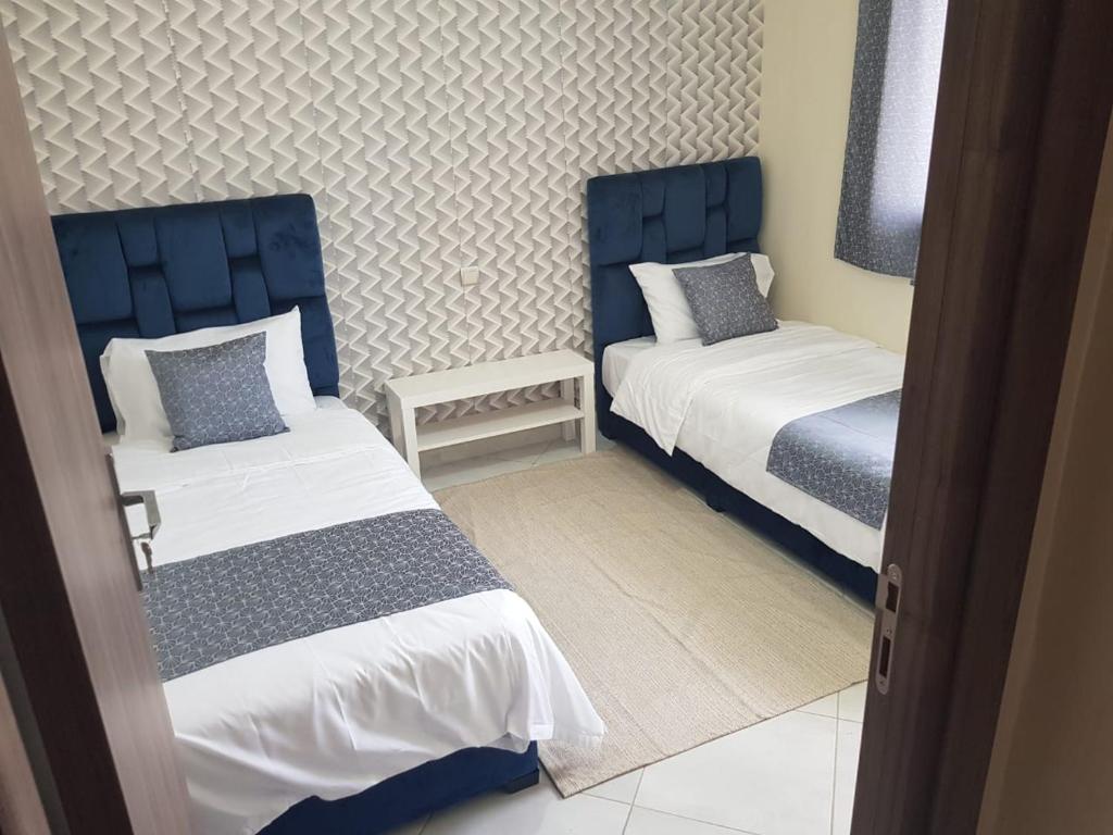 um quarto com 2 camas com cabeceiras azuis em APPART SMIR PARK em Tétouan