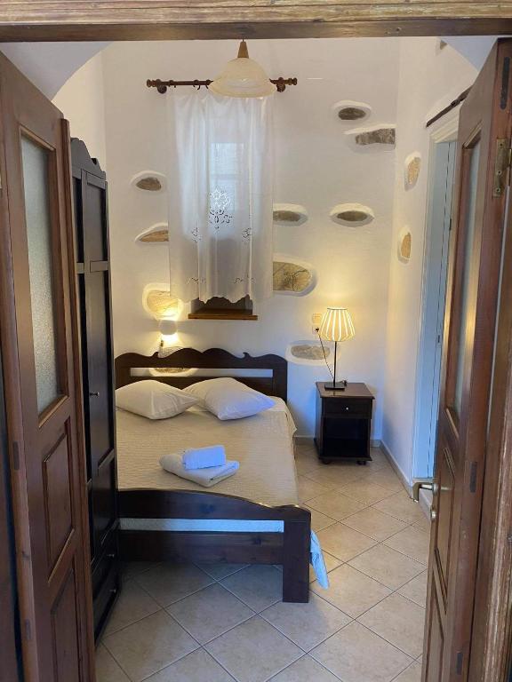 a bedroom with a bed with a chandelier at Pension Sofia Amorgos-Katapola in Katapola