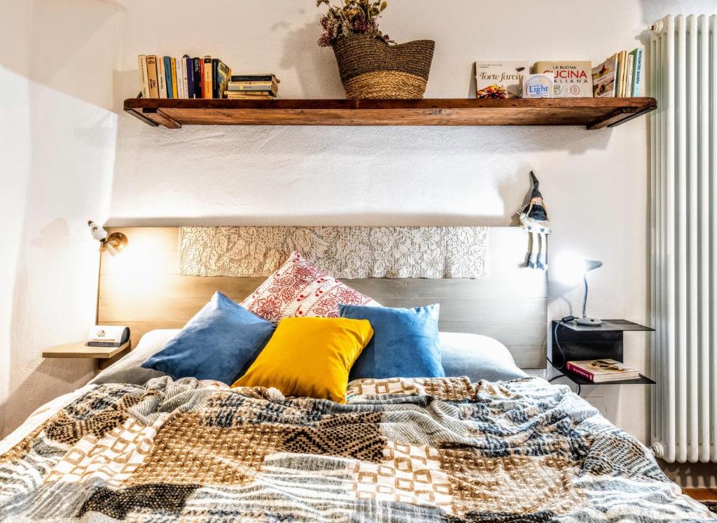 een slaapkamer met een bed met blauwe en gele kussens bij Casa Tòrta in Monticchiello