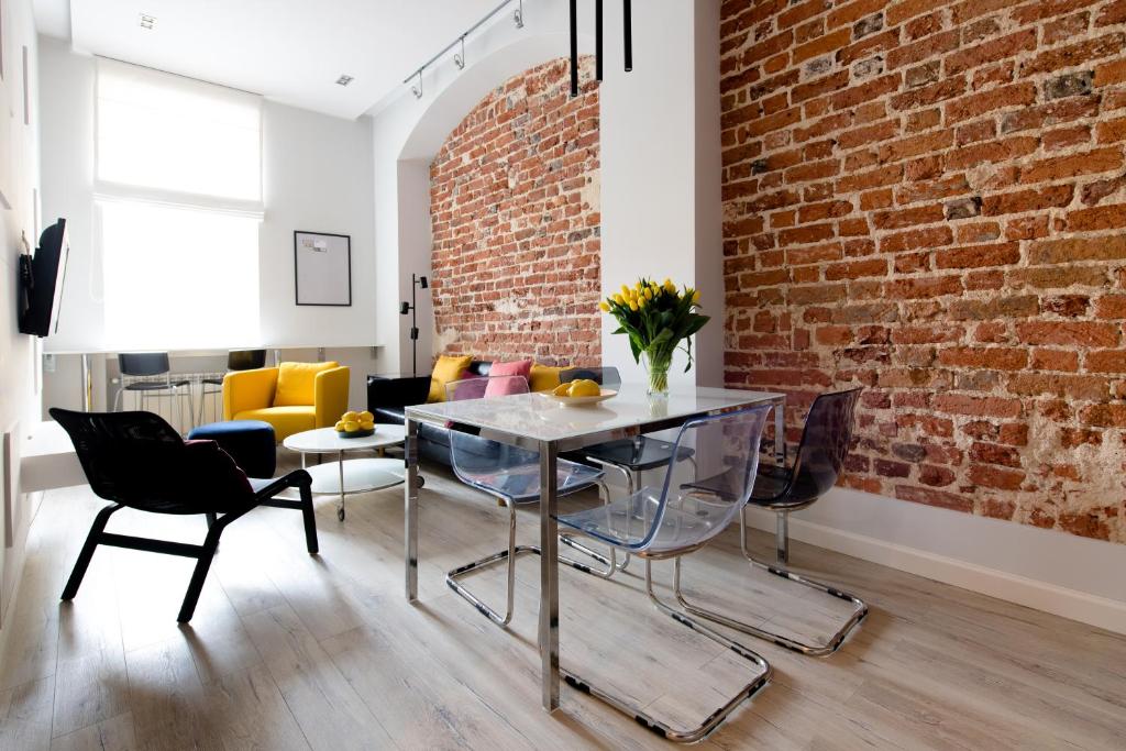 a dining room with a brick wall and a table and chairs at Apartament Rynek in Wrocław