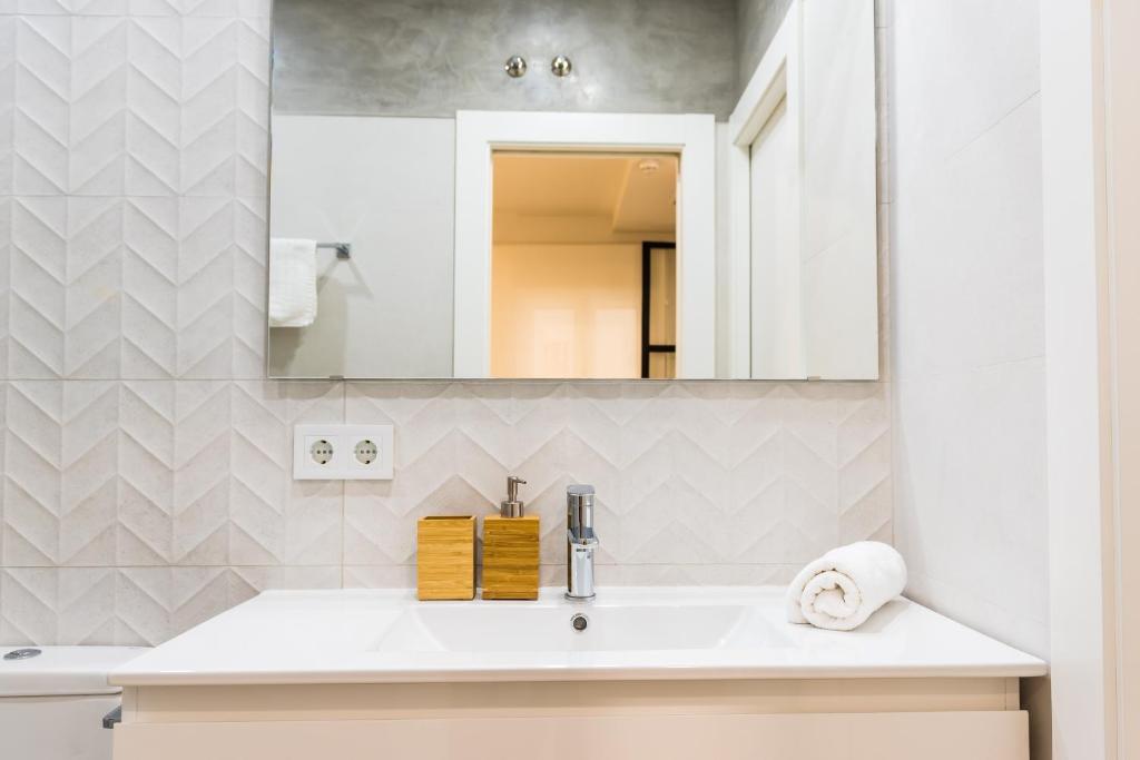 uma casa de banho com um lavatório e um espelho em TreeTriana em Sevilha