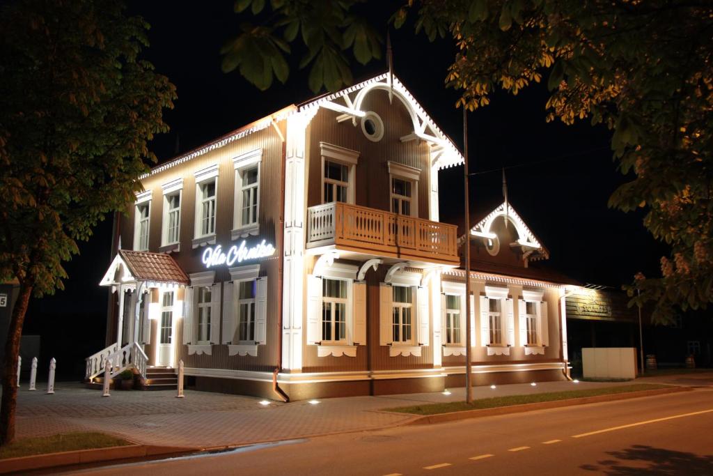 a lit up building on a street at night at Vila Arnika in Druskininkai