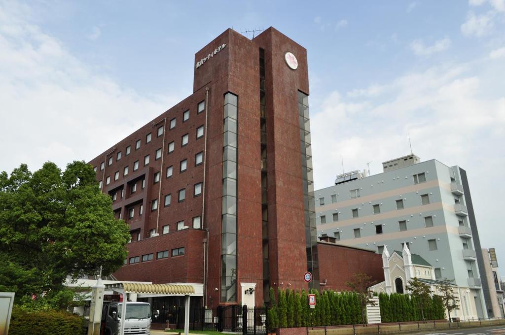 倉吉市にある倉吉シティホテルの時計付きの高いレンガ造りの建物