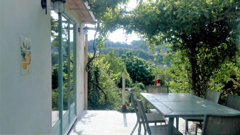 a table and chairs on a patio with a view at Le Coin Caché in Le Vigeant