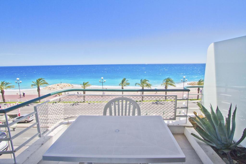a white table and chairs on a balcony with the beach at Florida Sea Front in Nice