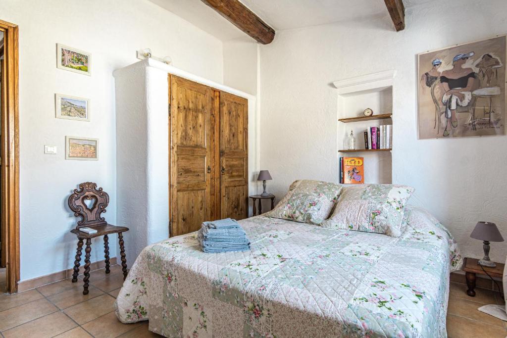 a bedroom with a bed and a wooden door at Maison de village au coeur de l'Isle-sur-la-Sorgue in L'Isle-sur-la-Sorgue