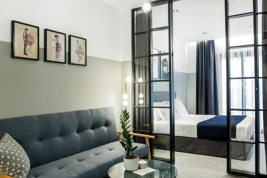 Habitación de hotel con cama y sofá en PAME Paradiso, en Atenas