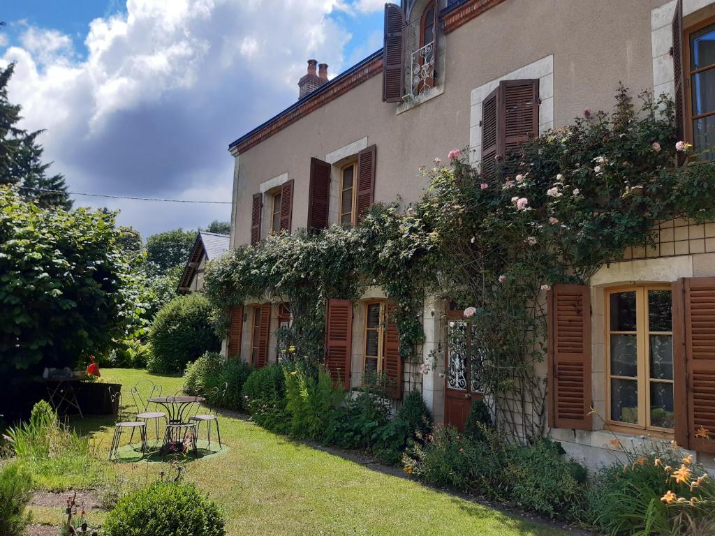 ein Haus mit Blumen auf der Seite in der Unterkunft le buisson de la gariole ,chambre rhétaise in Aubigny-sur-Nère