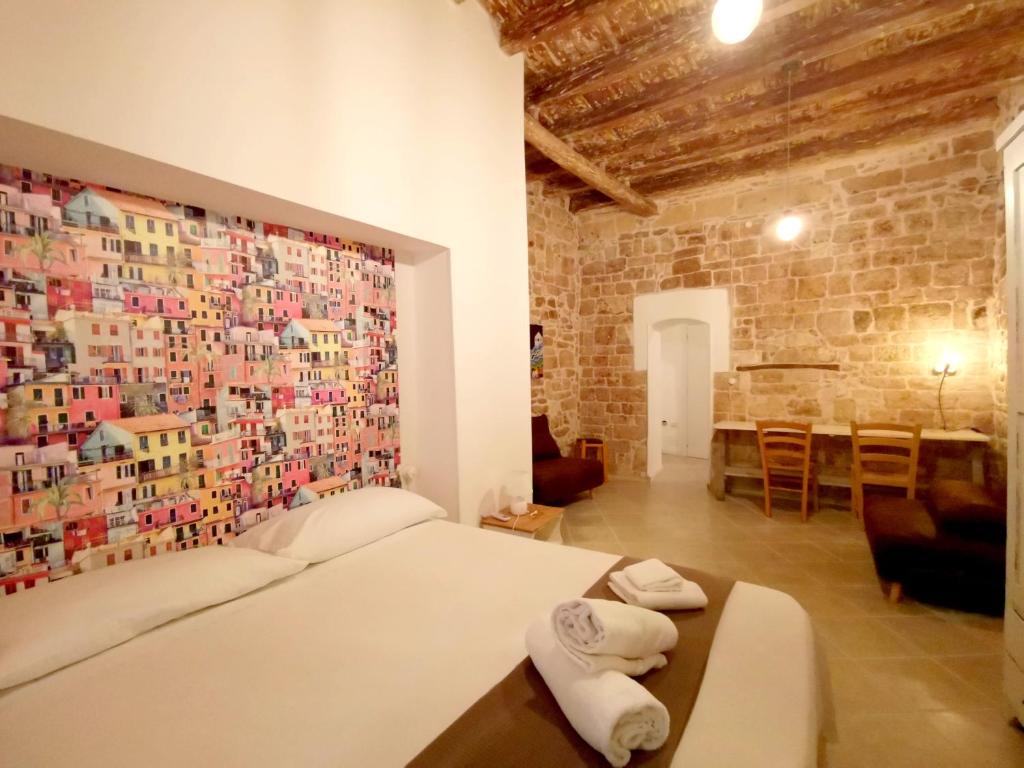 バーリにあるAppartamento Santa Manna, Bari Vecchiaの写真に覆われた壁のベッドルーム