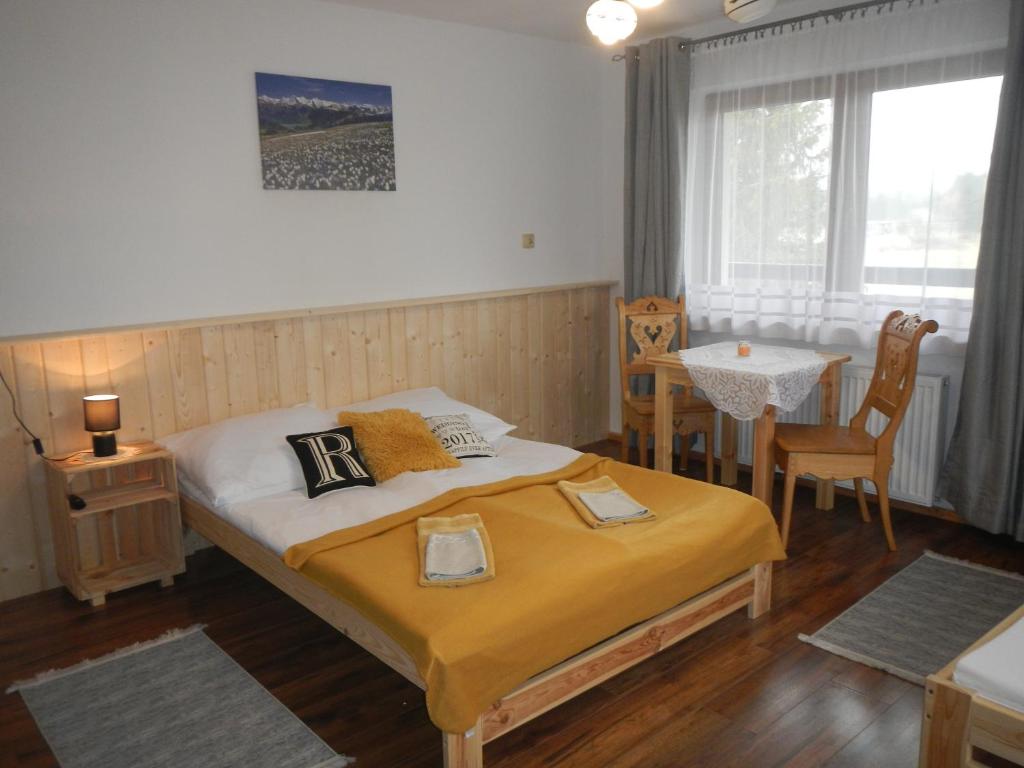 1 dormitorio con 1 cama, mesa y sillas en Wypoczynek Pod Skarpą, en Chochołów