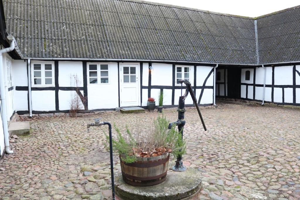 a white building with a black roof and a courtyard at Tøndegården 2 rooms apartment in Odense