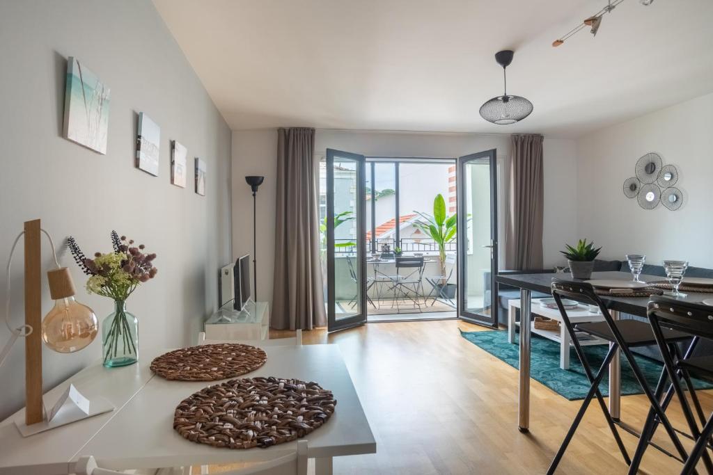 un salon avec une table et une salle à manger dans l'établissement Le Regatta, à Arcachon