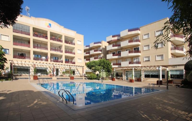 een zwembad voor een groot gebouw bij Costamarina Apartments in Cabo Roig
