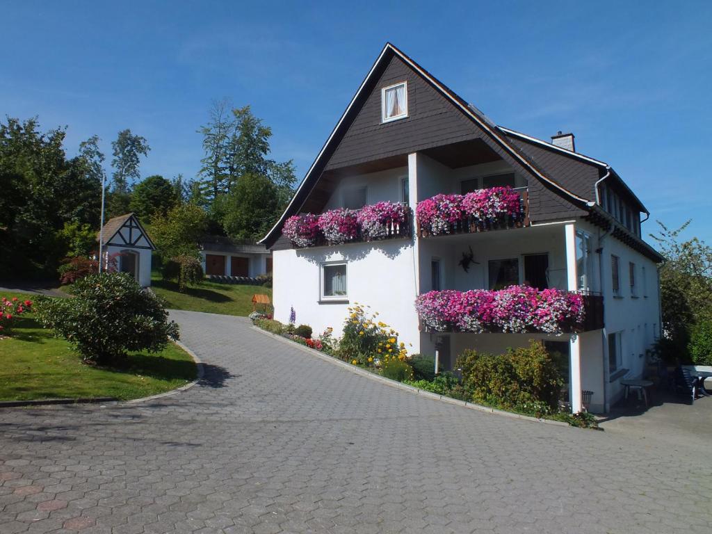 una casa con cajas de flores a un lado. en Ferienwohnung Hallmann en Schmallenberg