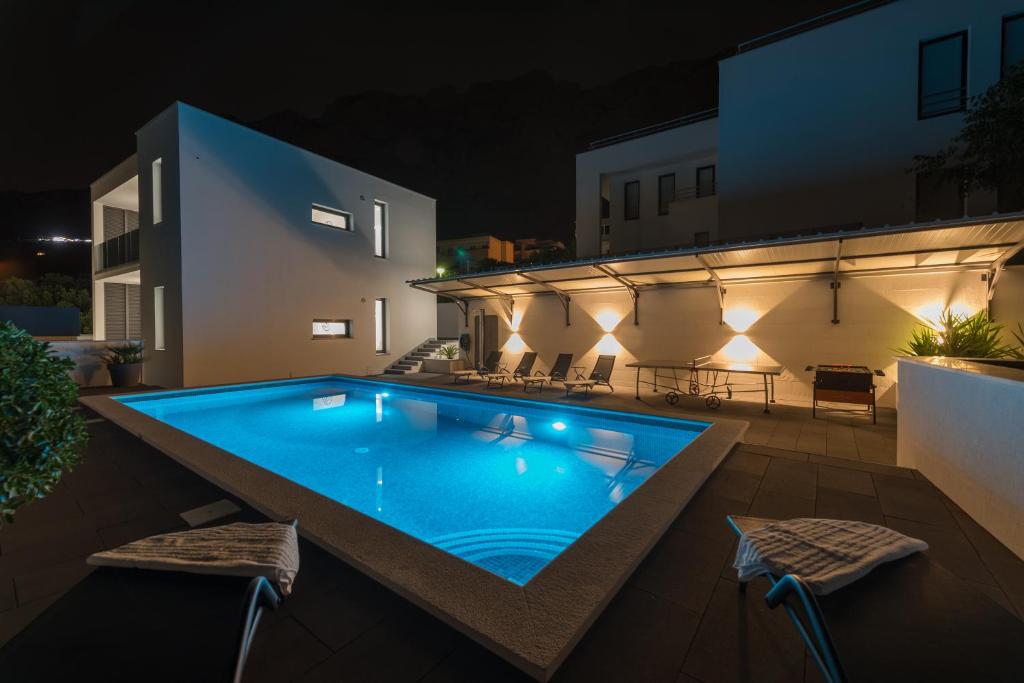 a swimming pool on the roof of a house at night at Villa Simon in Makarska