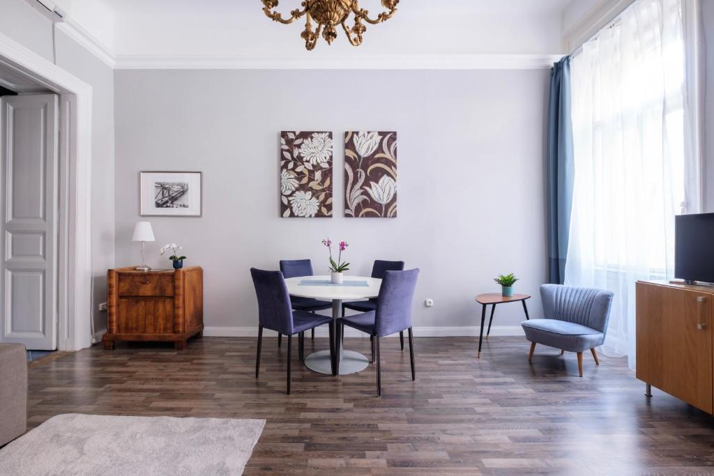 uma sala de jantar com mesa e cadeiras em New York Cafe Apartment in Center em Budapeste