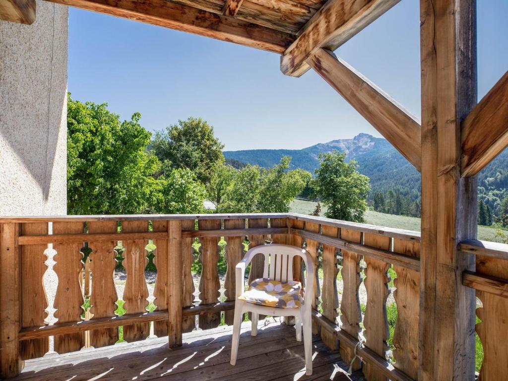 balcón de madera con silla y montañas en Huanzhof Ferienwohnung Schwarzhorn, en Aldino