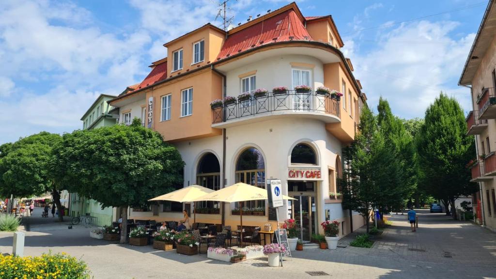 Un grand bâtiment avec balcon se trouve dans une rue. dans l'établissement City Hotel, à Piešťany