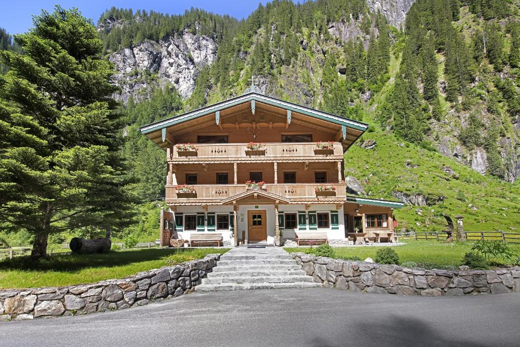 ein großes Gebäude auf einem Hügel mit einem Berg in der Unterkunft Alpenchalet Lacknerbrunn bis 23 P in Mayrhofen