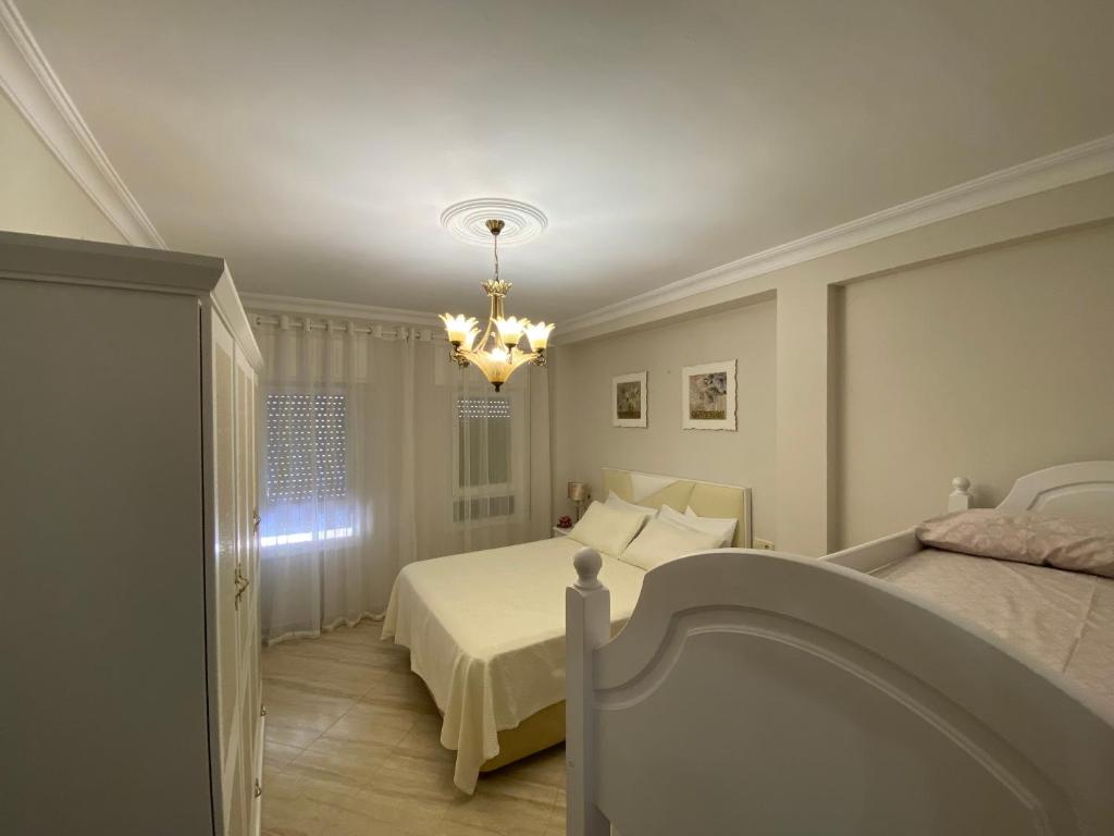 トレモリノスにあるPerla Del Sol 1 lのベッドルーム1室(ベッド1台、シャンデリア付)