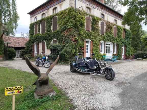 a couple of motorcycles parked in front of a house at LA BELLE D'ANTAN in Saint-Bonnet-en-Bresse