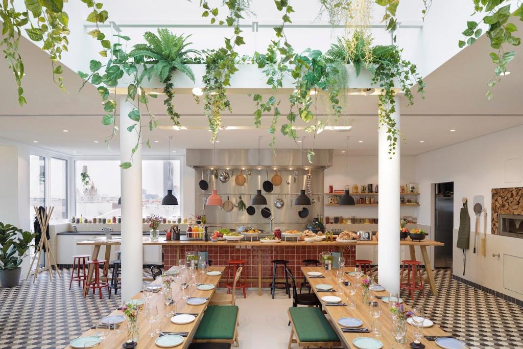 a dining room with tables and a kitchen at Zoku Vienna in Vienna