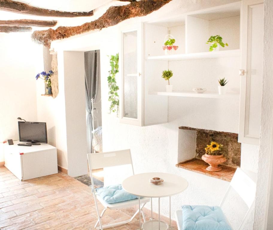 Habitación con mesa, sillas y chimenea. en Casa nella roccia en Bomarzo