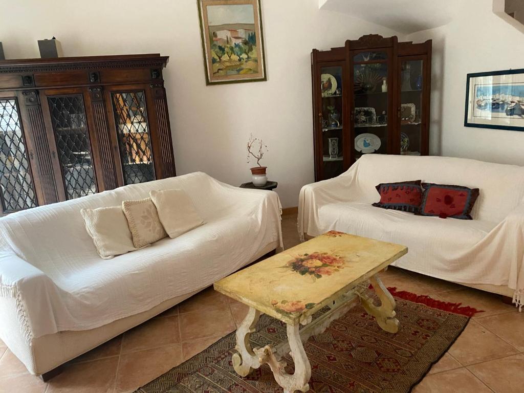 a living room with two white couches and a coffee table at Sea home in Alghero