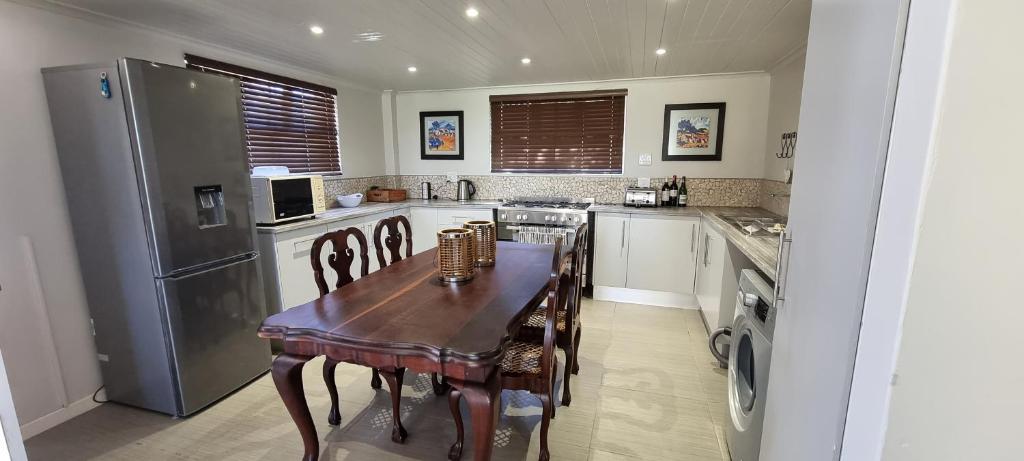 a kitchen with a wooden table and a refrigerator at DullVino First House in Dullstroom