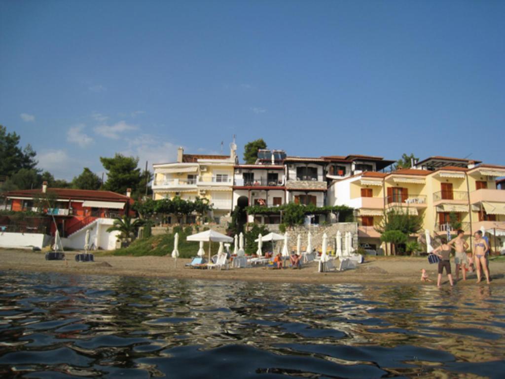 a group of people standing on the beach near the water at Giannis Maria Apartments in Psakoudia