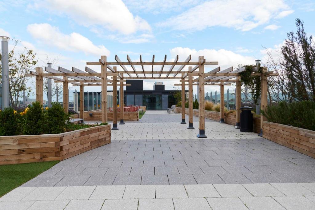 a wooden pergola in front of a building at Chic Apartments and Private Bedrooms at Beckett House near Dublin City Centre in Dublin