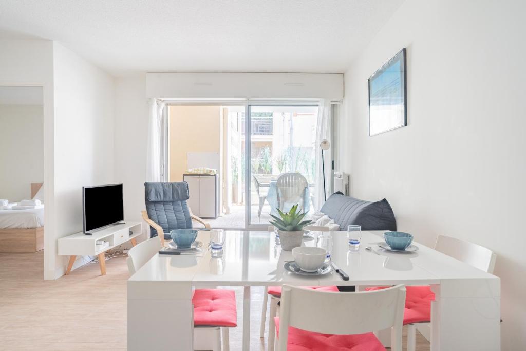 a white living room with a white table and chairs at La Pause Bassin, charmant appartement dans le centre in Arcachon
