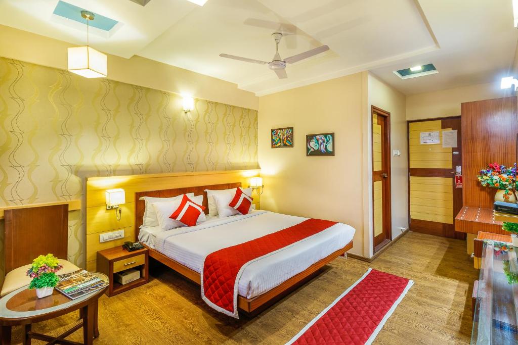 a hotel room with a bed and a table at Octave Kanthi Comforts in Bangalore