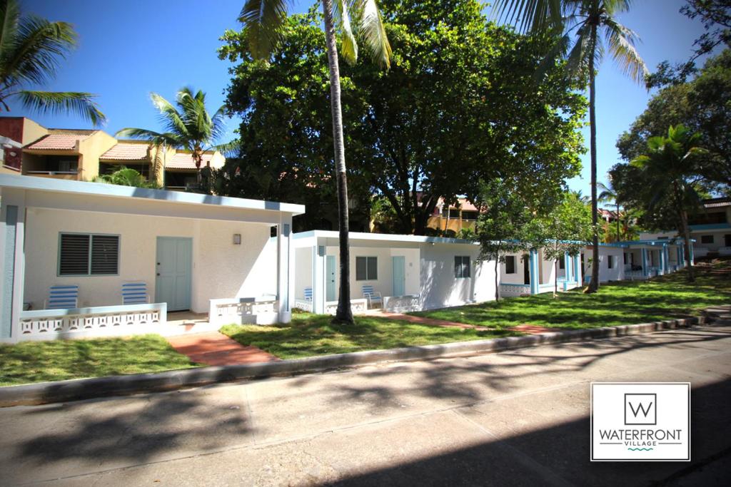 een uitzicht op de straat van een huis met palmbomen bij Bungalow 14 Cozy room at just steps from the beach and in town center in Sosúa