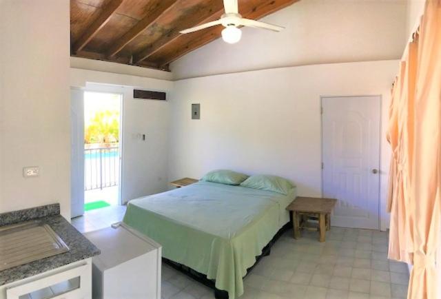 um quarto com uma cama e uma ventoinha de tecto em Bungalow 17 Cozy room at just steps from the beach and in town center em Sosúa