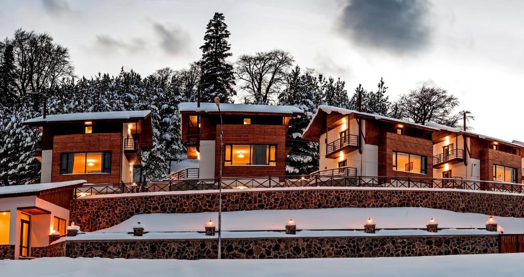 uma casa na neve com uma ponte em Crystal Hill Resort em Bakuriani