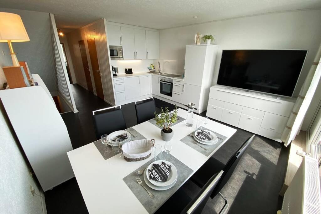 een kleine keuken met een tafel en een koelkast bij PENTHOUSE mitten im BAYERISCHEN WALD +NETFLIX +AUSSICHT = SUPER COZY in Sankt Englmar