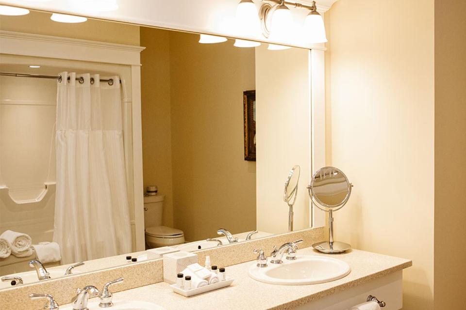 a bathroom with a sink and a large mirror at Riverbend Inn & Vineyard in Niagara on the Lake