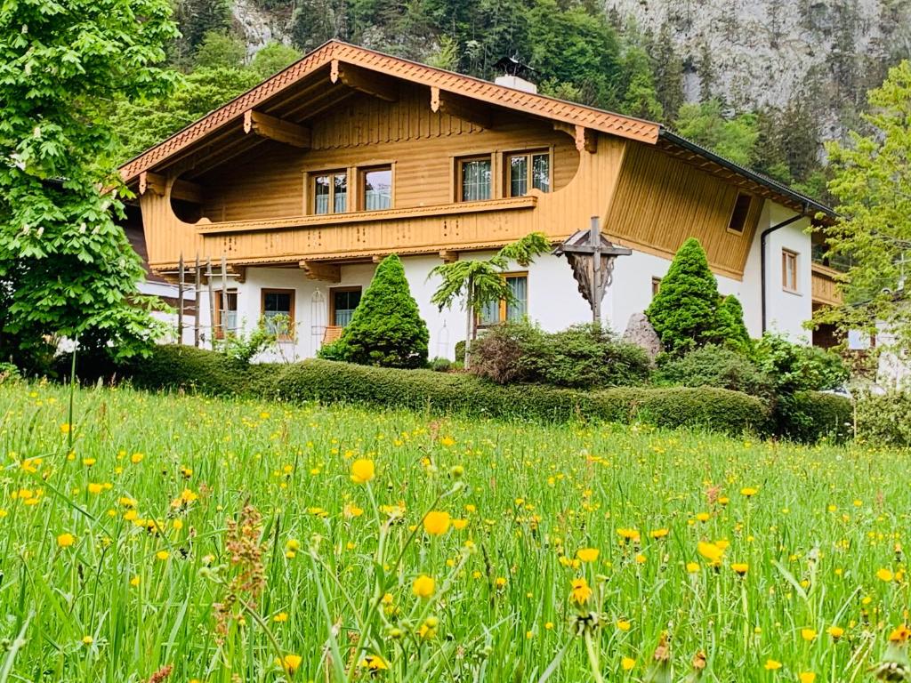 dom z polem kwiatów przed nim w obiekcie Appartement Top Tirol w mieście Maurach