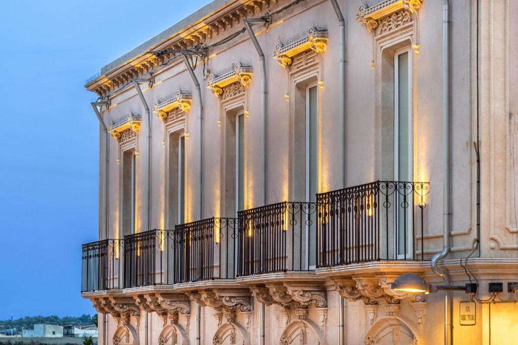 - un bâtiment avec un balcon sur le côté dans l'établissement Casa Ruiz Suites, à Noto