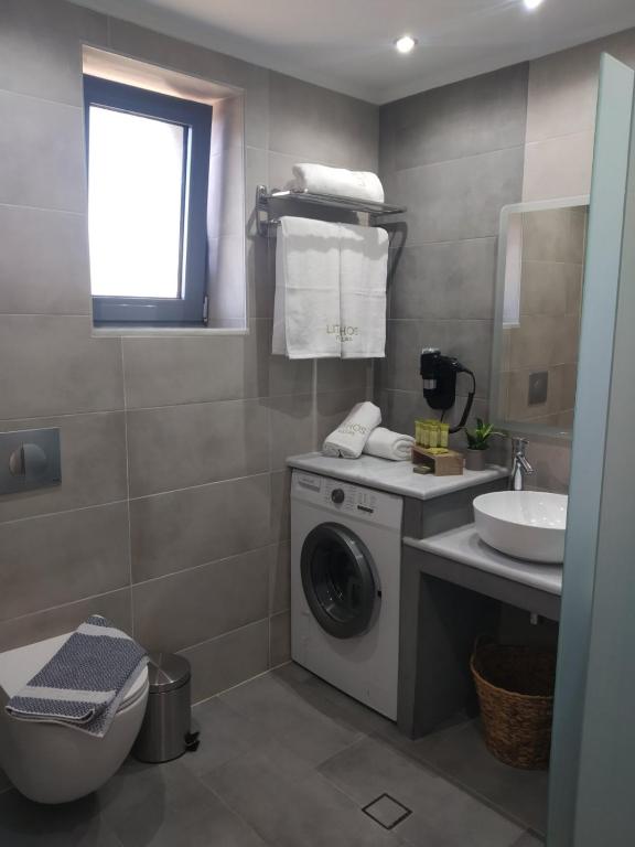 W łazience znajduje się pralka i umywalka. w obiekcie Lithos Villas w mieście Skala Eresou
