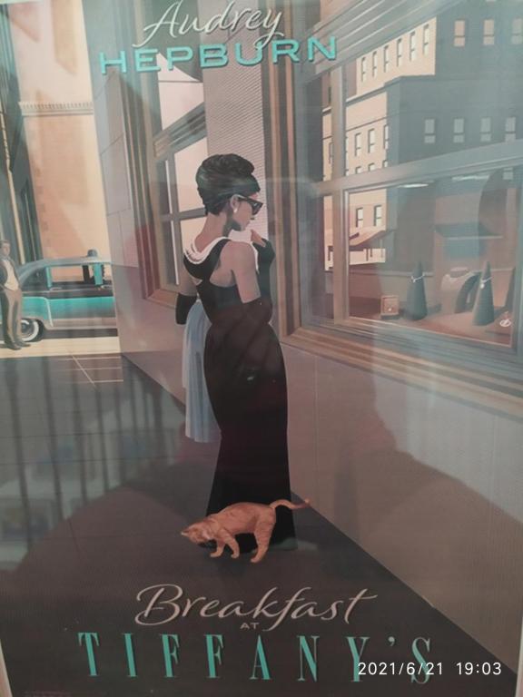 un póster de una mujer con un vestido negro en una pared en B&B Tiffany, en Palinuro
