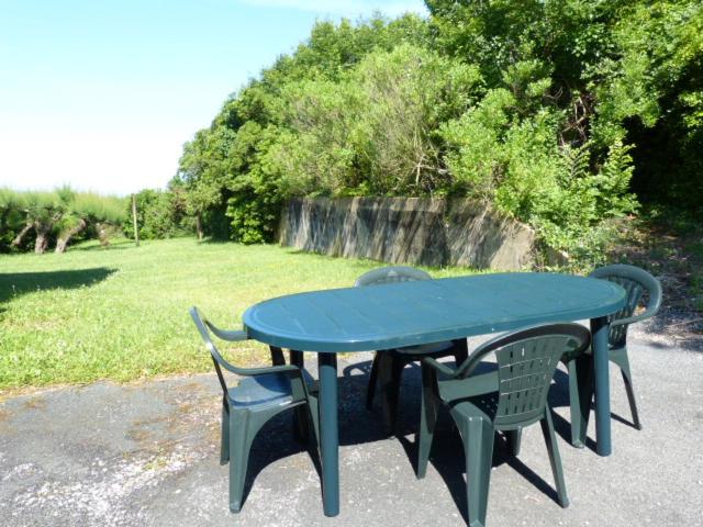 un tavolo blu e due sedie sedute accanto a un campo di Chibau Berria-Aperçu mer et montagne à côté de la plage a Saint-Jean-de-Luz