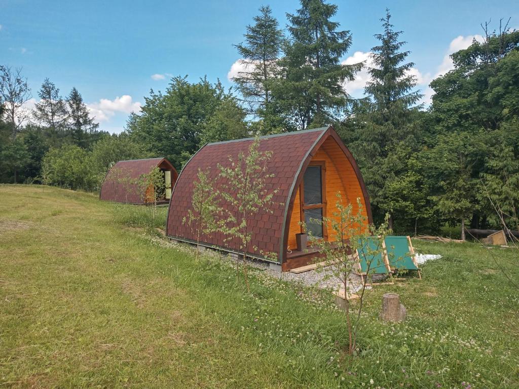 a couple of small buildings in a field at Domek Wilcza Wola 2 in Górzanka