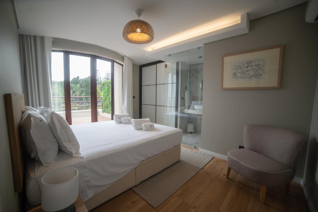 a bedroom with a bed and a window and a chair at Rooftop Marina l by Madeira Best Apartments in Funchal